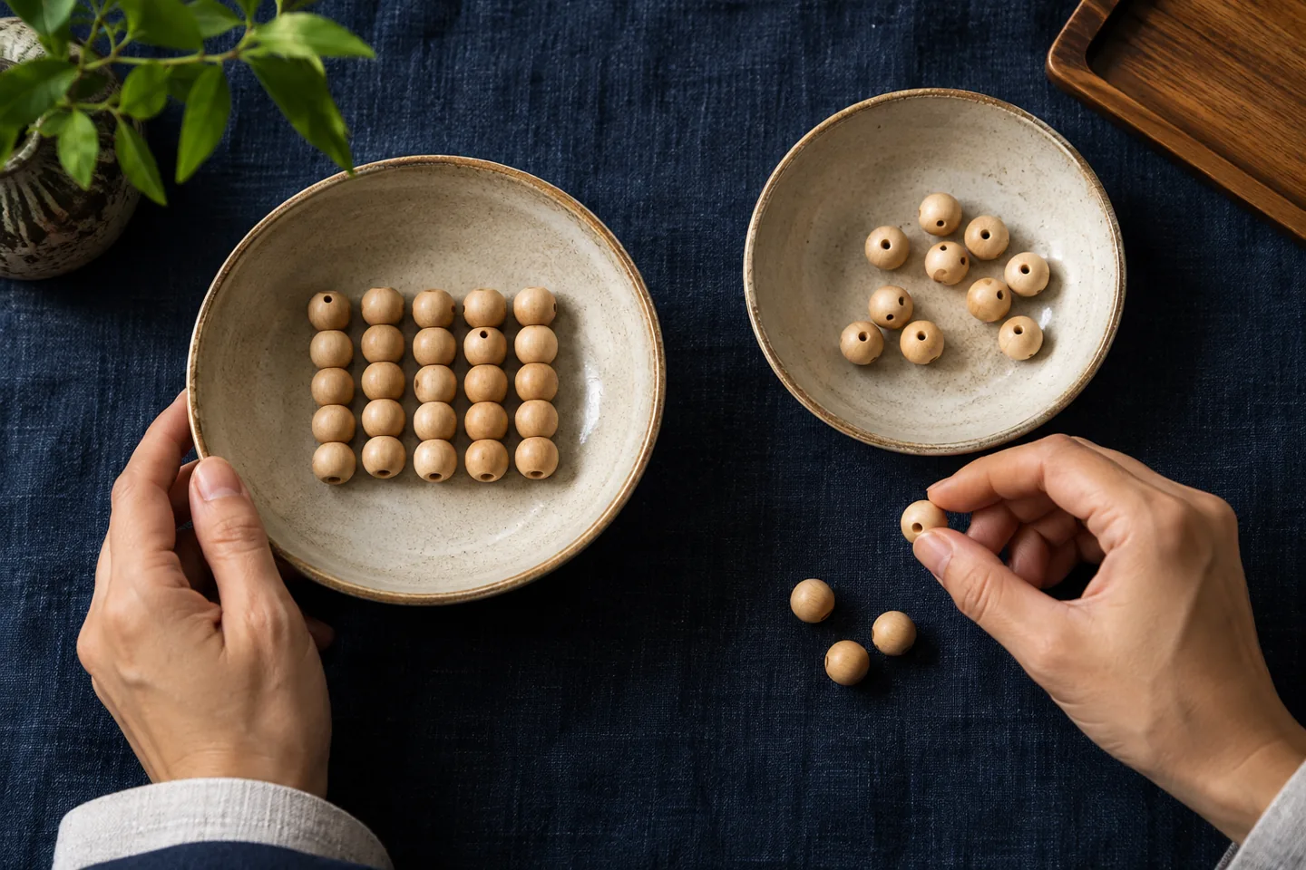 Wooden counting beads in two ceramic bowls on dark indigo cloth