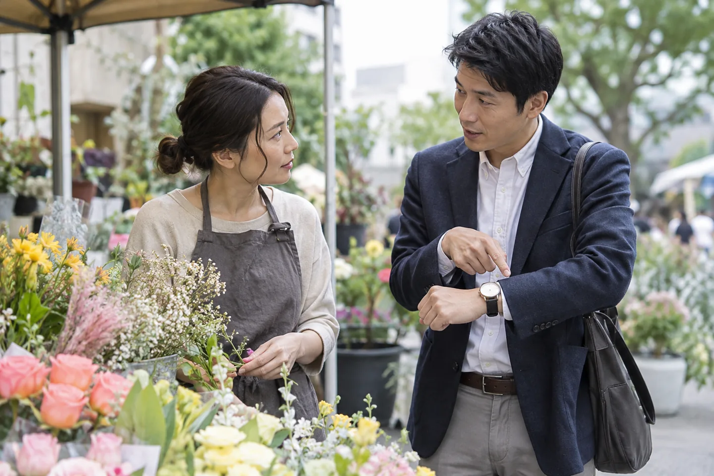 Two adults confirming an appointment beside flowers at an outdoor stall